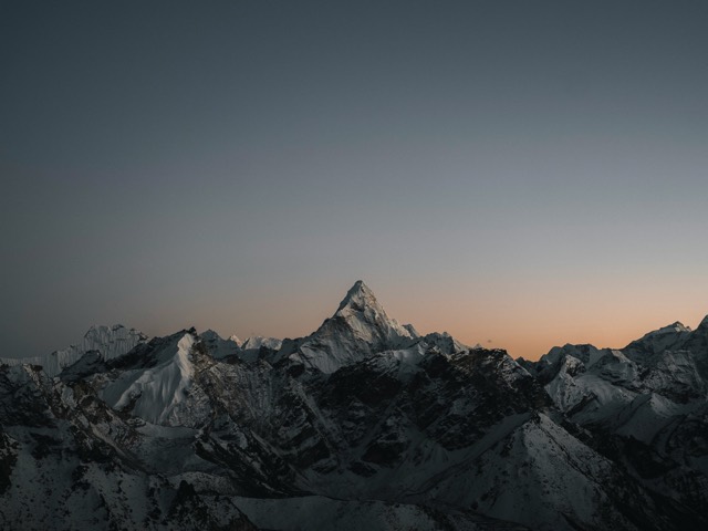 Jagged mountain peaks fading into evening light