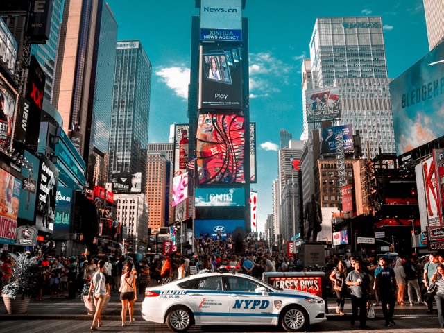 Times Square filled with signs, traffic, and pedestrians